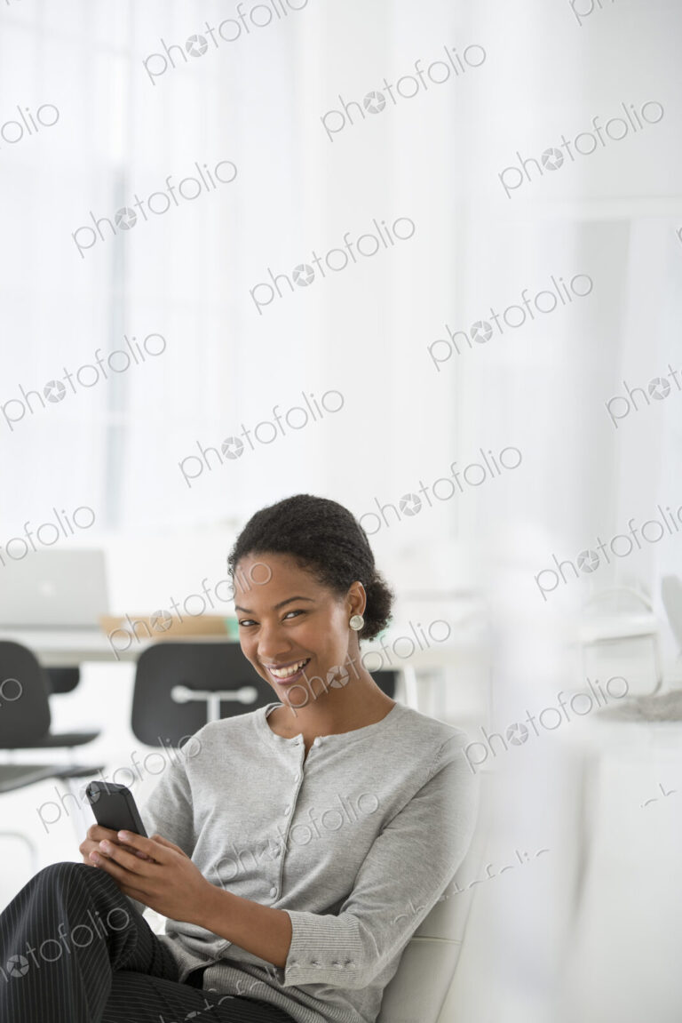 An office in the city. Business. A woman seated in a comfortable chair, checking her…