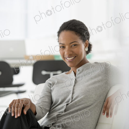 An office in the city. Business. A woman seated on the sofa looking relaxed. An office in the city. Business. A woman seated on the sofa looking relaxed.