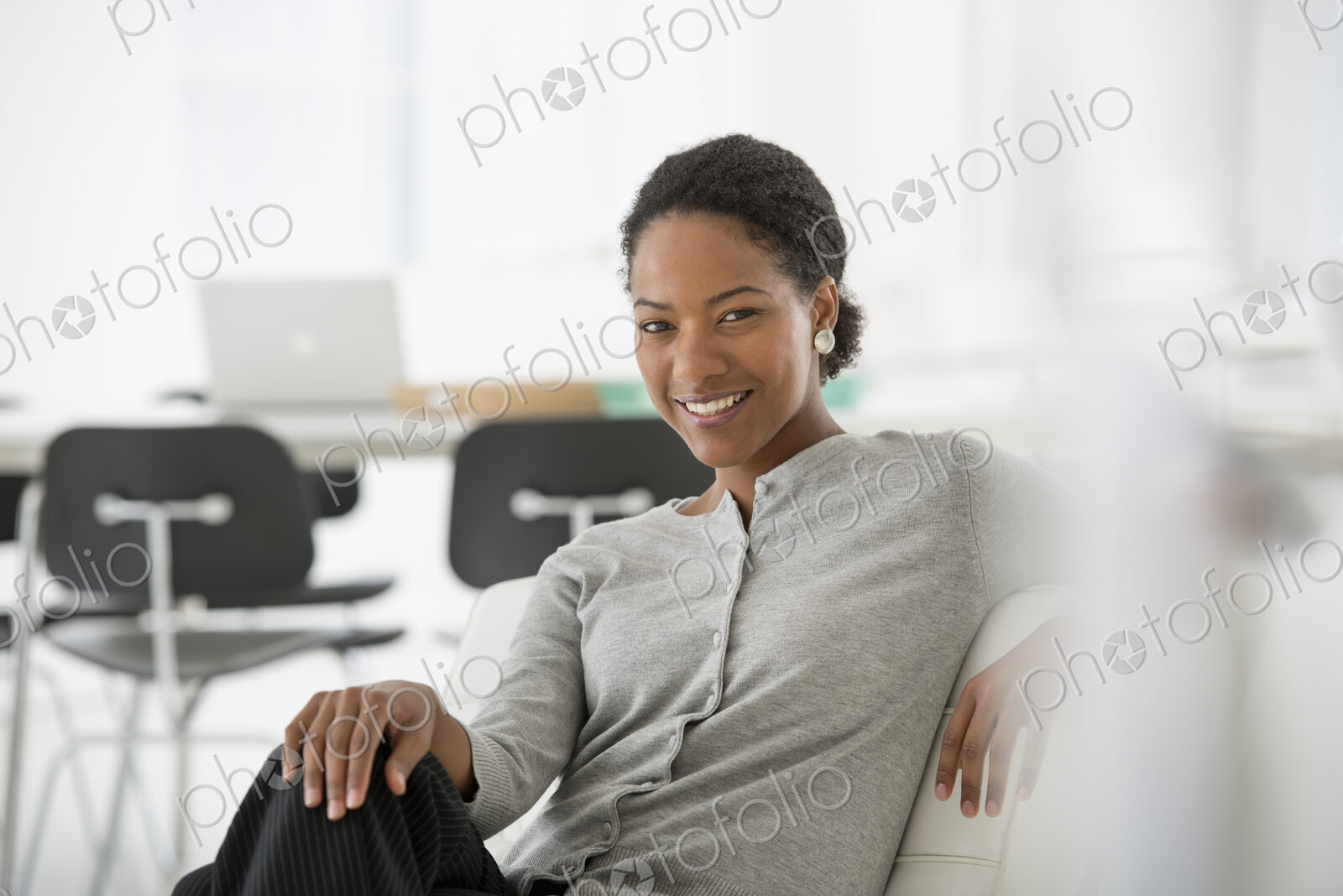 An office in the city. Business. A woman seated on the sofa looking relaxed.