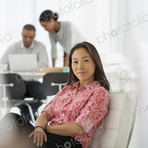 An office in the city. Business. A woman seated on the sofa looking relaxed. Two…