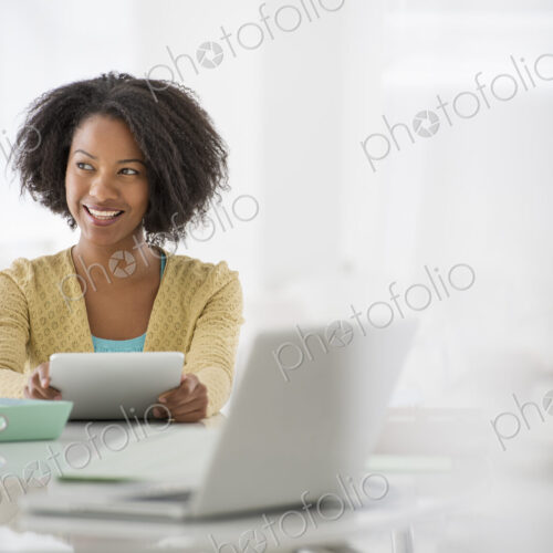 An office in the city. Business. A woman sitting at a desk. Digital tablet and laptop,…