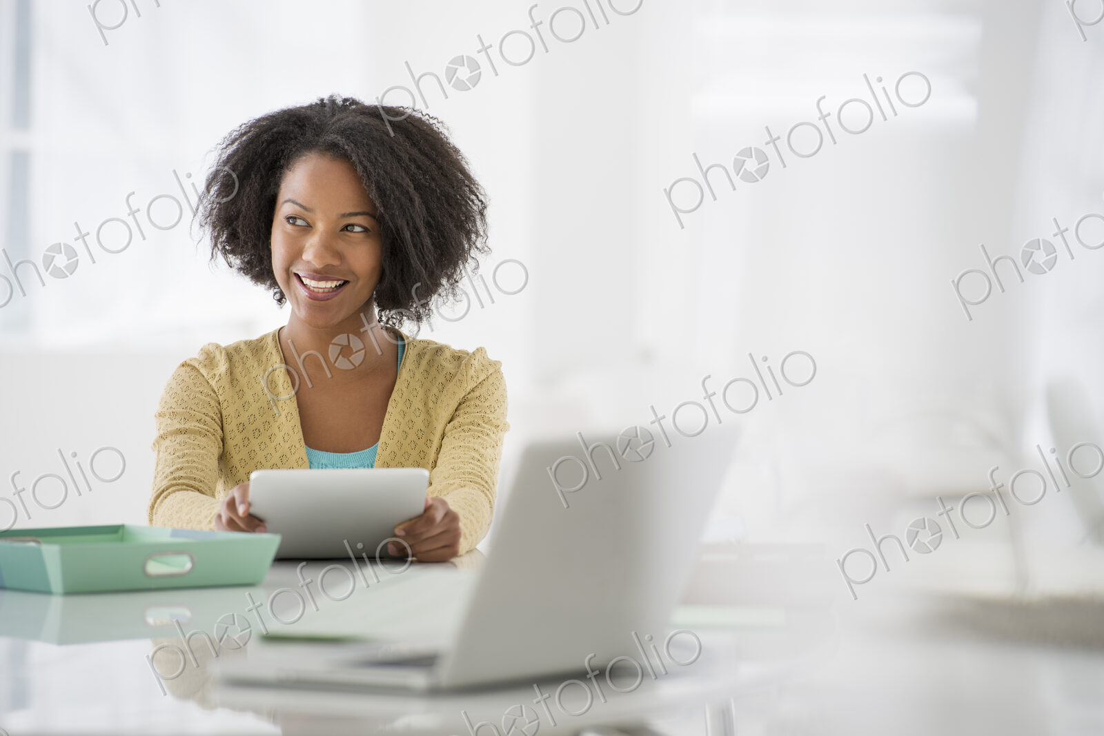 An office in the city. Business. A woman sitting at a desk. Digital tablet and laptop,…