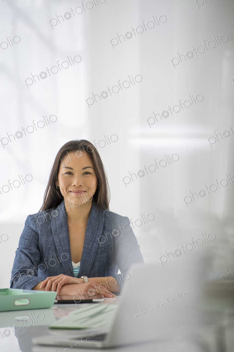An office in the city. Business. A woman sitting at a desk. Digital tablet and laptop,…