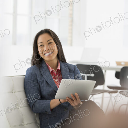 An office in the city. Business. A woman sitting down using a digital tablet. An office in the city. Business. A woman sitting down using a digital tablet.