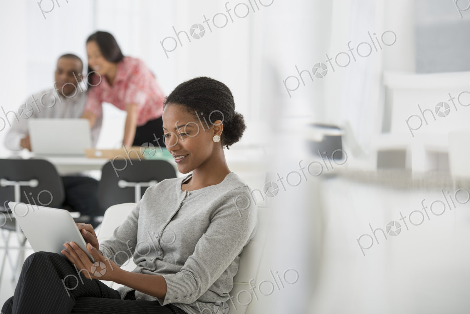 An office in the city. Business. A woman sitting down using a digital tablet. Two…