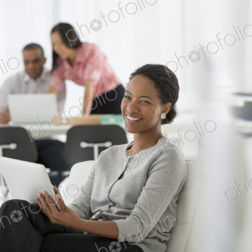 An office in the city. Business. A woman sitting down using a digital tablet. Two…