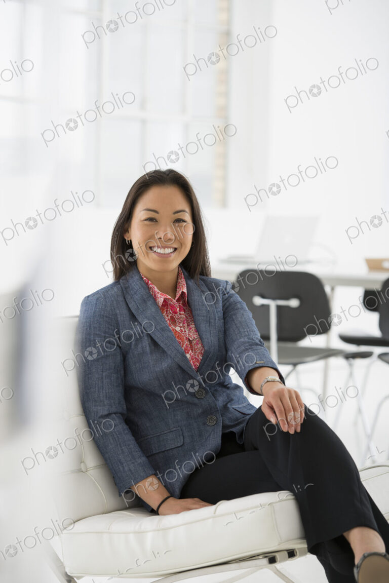 An office in the city. Business. A woman sitting relaxing on a comfortable chair.