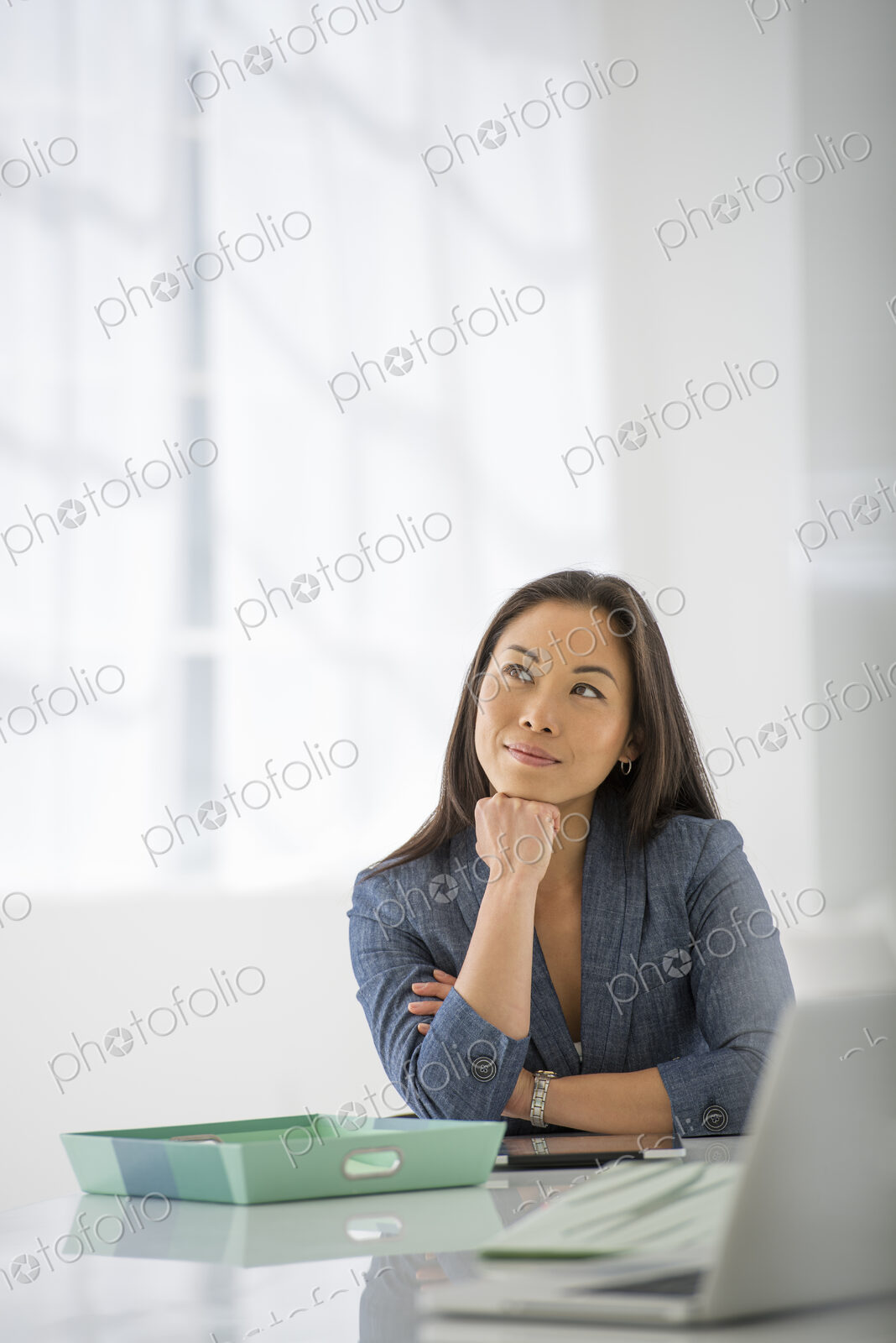 An office in the city. Business. A woman sitting relaxing, with her chin on her hand.…