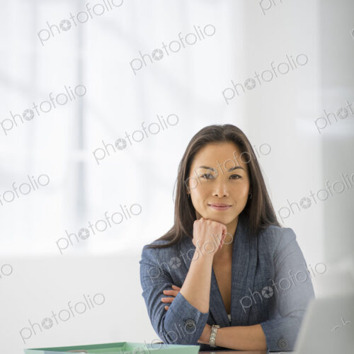 An office in the city. Business. A woman sitting relaxing, with her chin on her hand.… An office in the city. Business. A woman sitting relaxing, with her chin on her hand.…