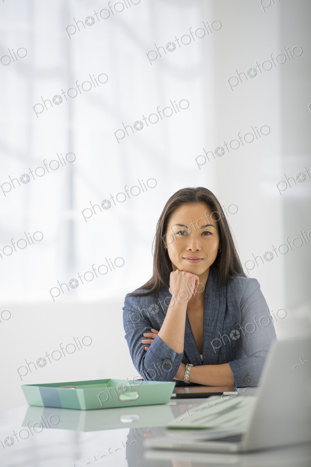 An office in the city. Business. A woman sitting relaxing, with her chin on her hand.…