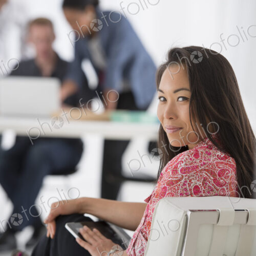 An office in the city. Business. A woman sitting with a digital tablet on her lap,…