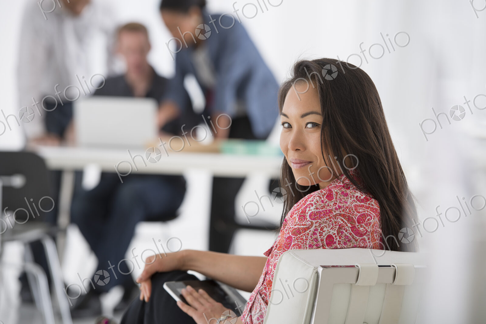 An office in the city. Business. A woman sitting with a digital tablet on her lap,…