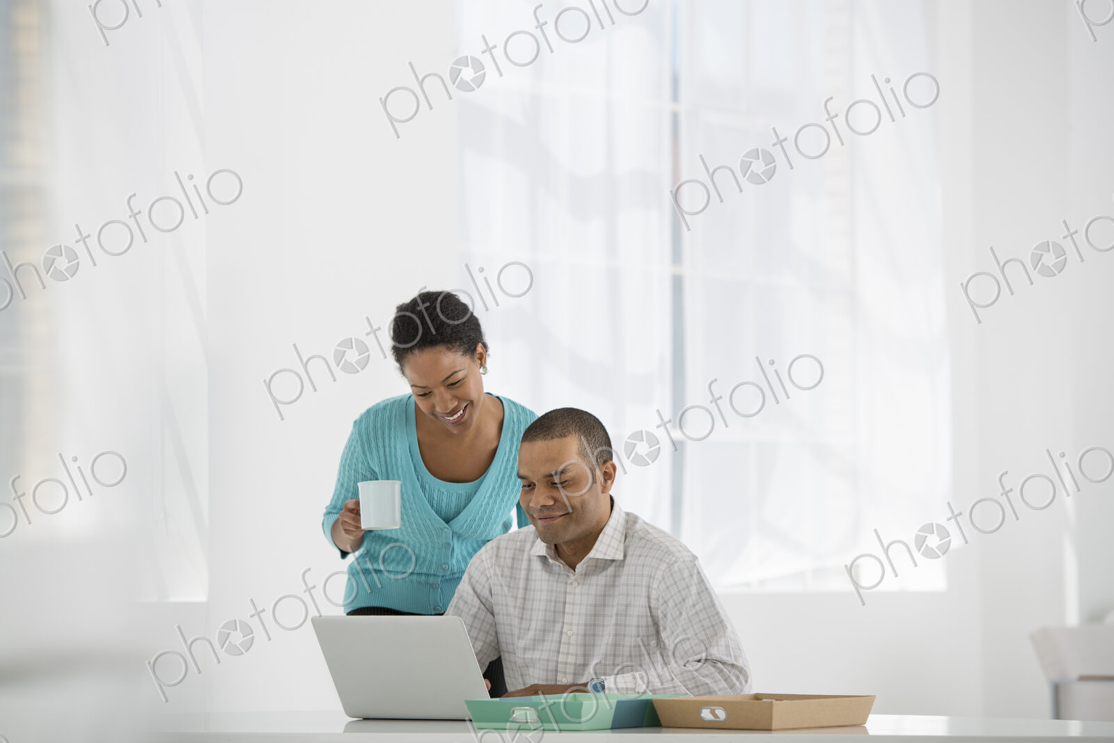 An office in the city. Business. A woman with a cup of coffee and a man looking at a…