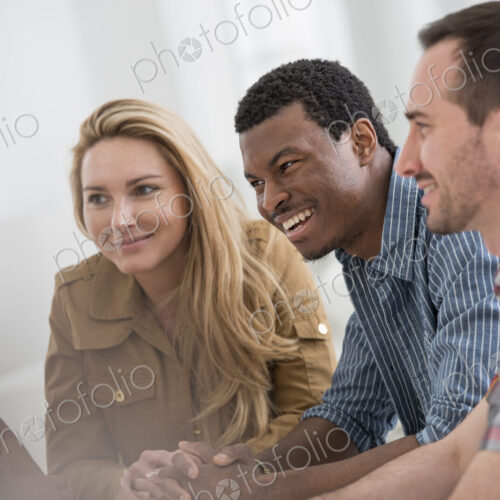 An office interior flooded with light. A group of four people, two men and two women…