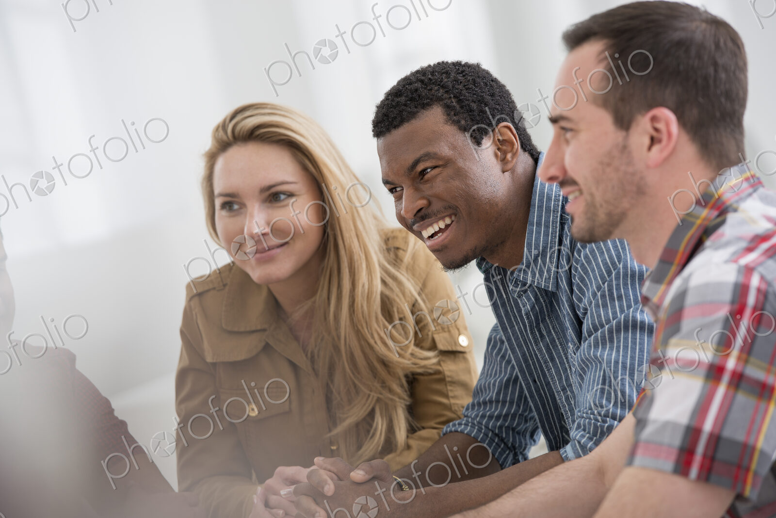 An office interior flooded with light. A group of four people, two men and two women…
