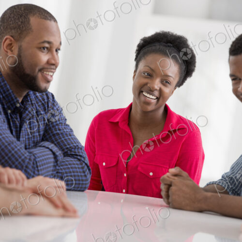 An office interior flooded with light. A group of four people, two men and two women…