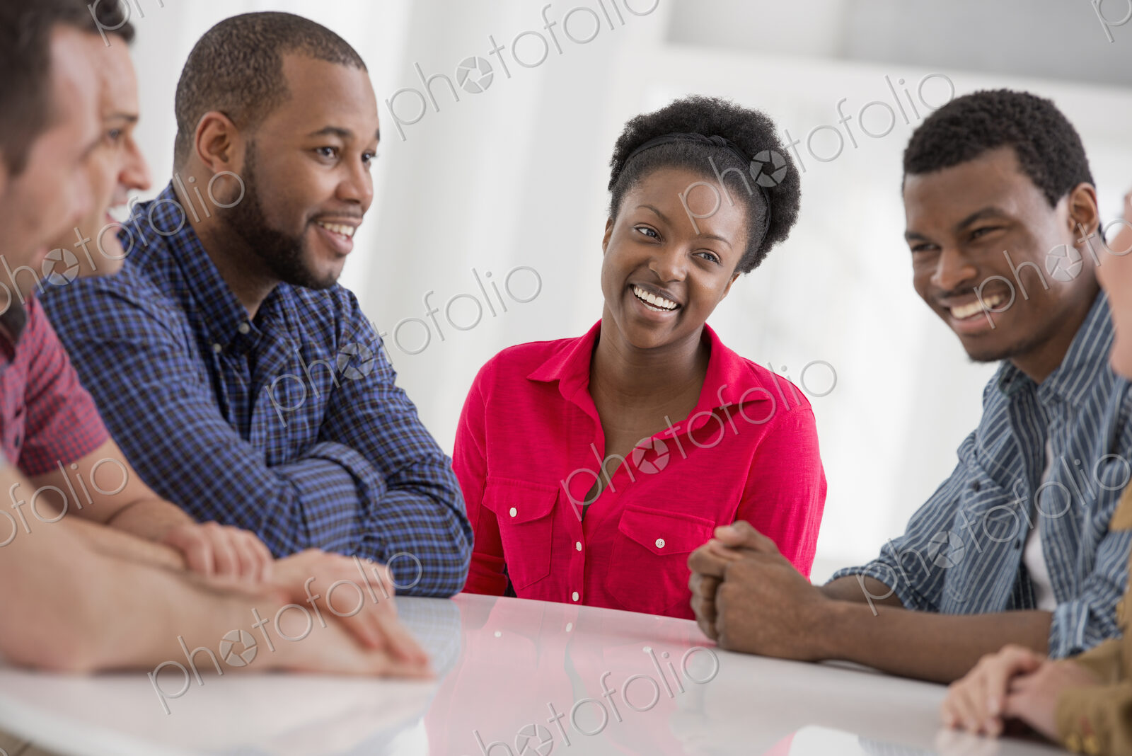 An office interior flooded with light. A group of four people, two men and two women…