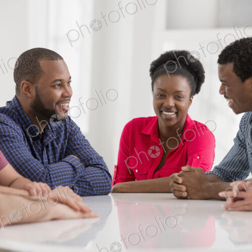 An office interior flooded with light. A group of four people, two men and two women…