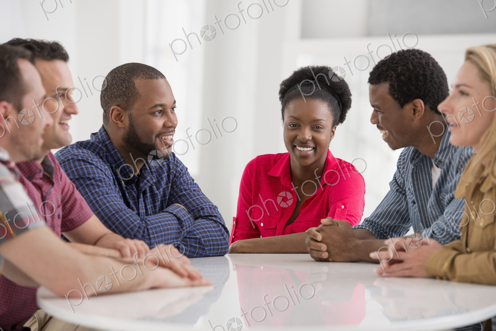An office interior flooded with light. A group of four people, two men and two women…