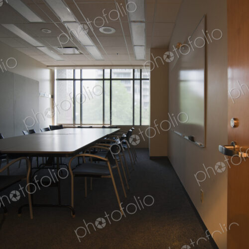 An office interior with door open to empty boardroom.