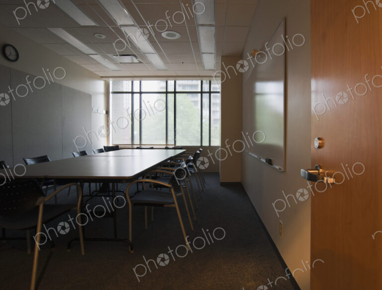 An office interior with door open to empty boardroom.