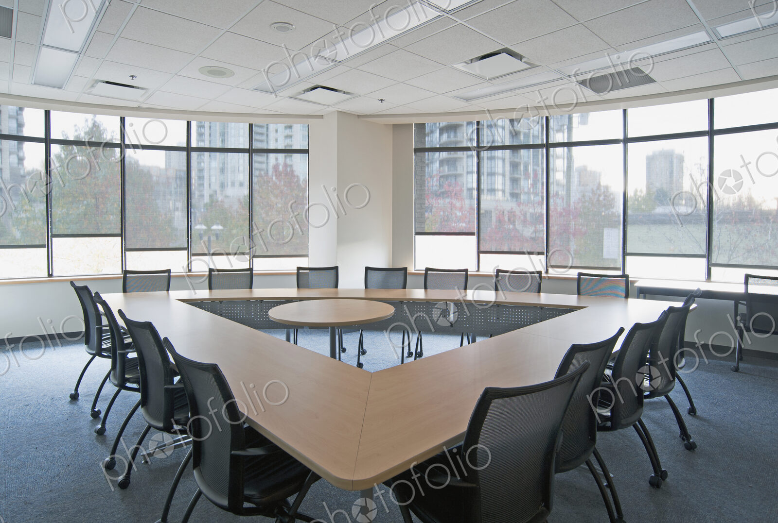 An office meeting room with windows, a long table and chairs.