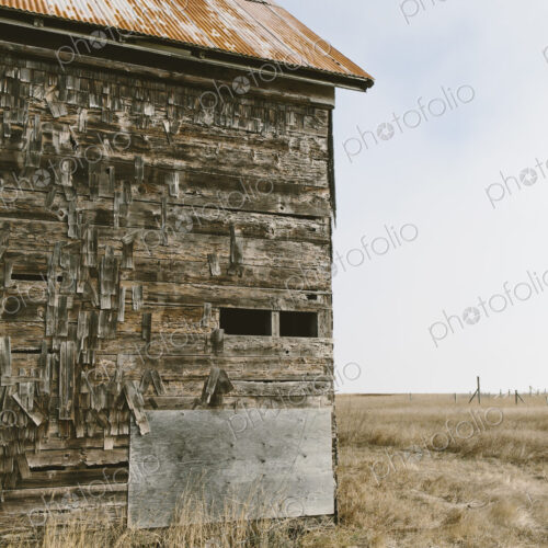 An old abandoned farmhouse with wooden shingle tiles on the walls. Silvery grey colours. An old abandoned farmhouse with wooden shingle tiles on the walls. Silvery grey colours.