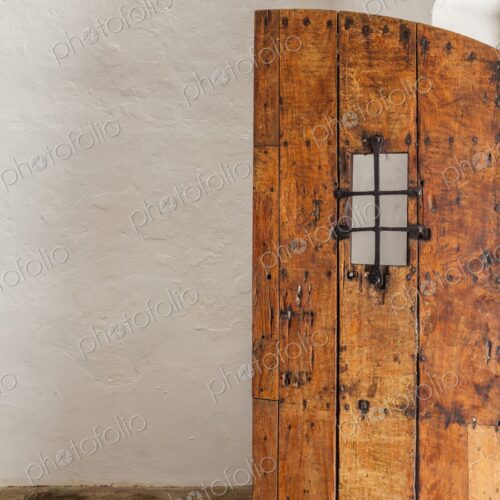 An old wooden door with iron grate detail stands partially open inside Castillo San… An old wooden door with iron grate detail stands partially open inside Castillo San…