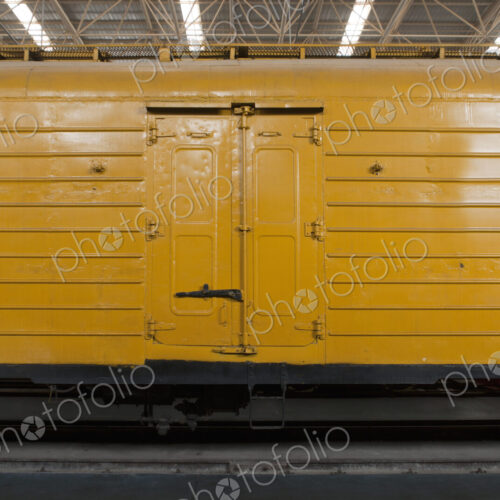 An old yellow train in a train shed.
