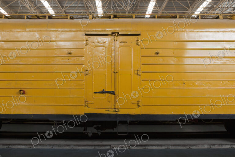 An old yellow train in a train shed.