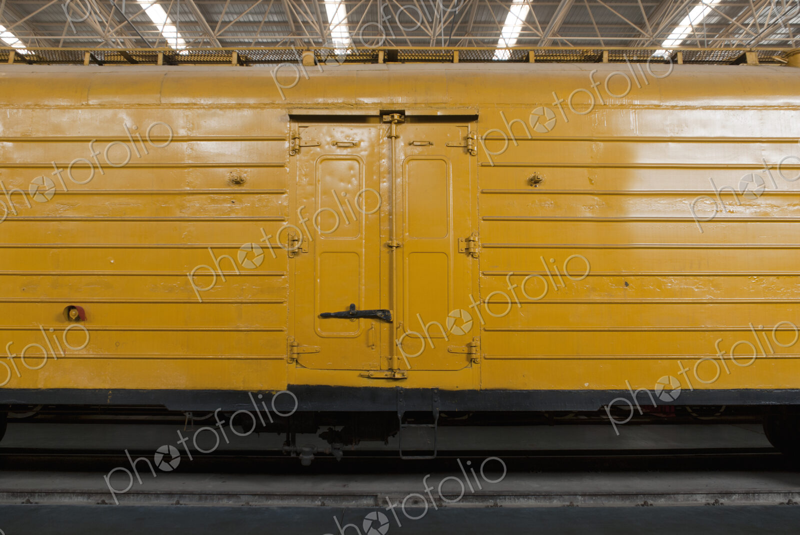 An old yellow train in a train shed.
