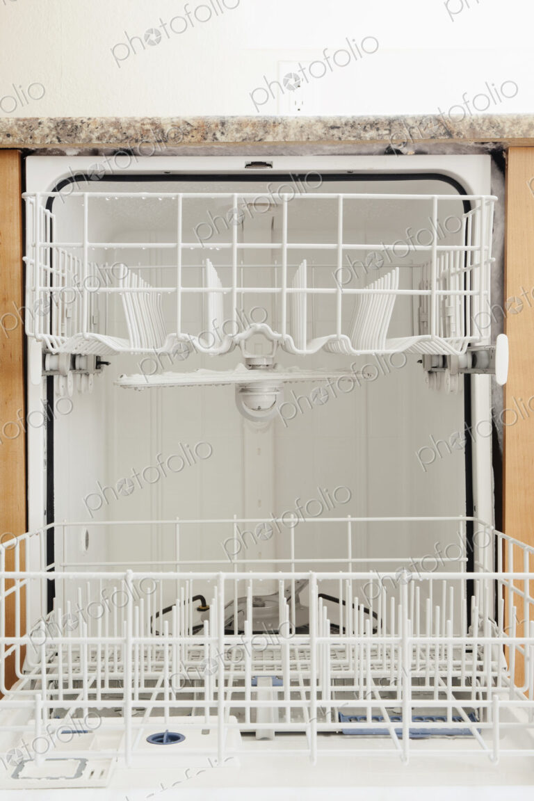 An open dishwasher in a kitchen.