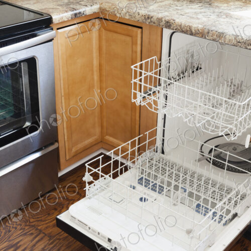 An open dishwasher in a kitchen. An open dishwasher in a kitchen.