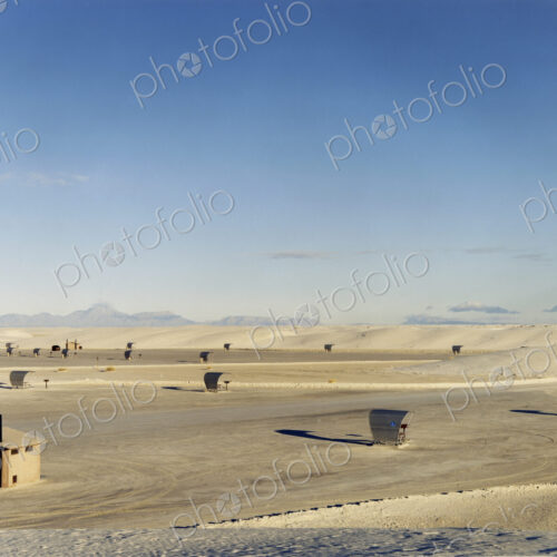 An open space a desert landscape, with a small cabin and sun shelters, surrounded by… An open space a desert landscape, with a small cabin and sun shelters, surrounded by…