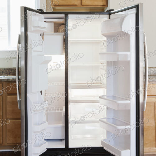 An open stainless steel double door refrigerator in kitchen. An open stainless steel double door refrigerator in kitchen.