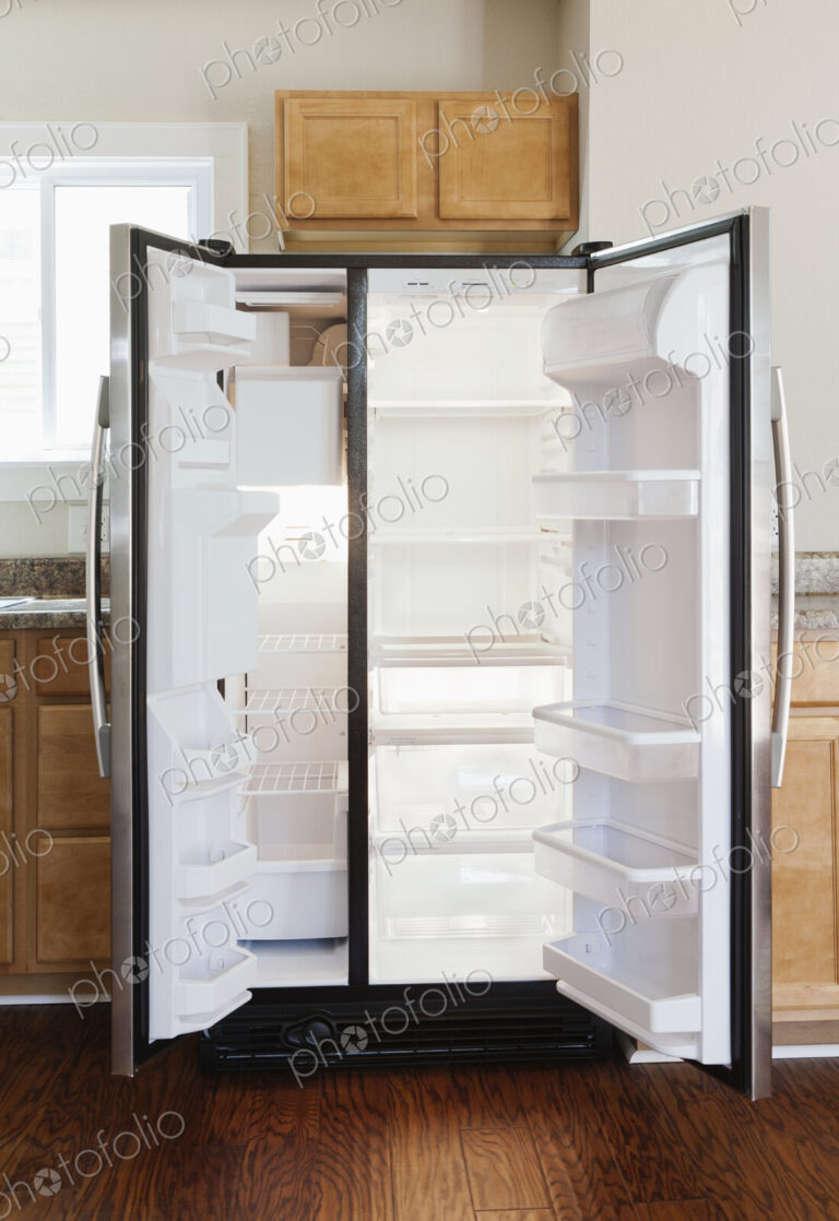 An open stainless steel double door refrigerator in kitchen.