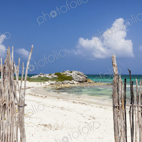 An opening in the fence onto a white sand beach An opening in the fence onto a white sand beach