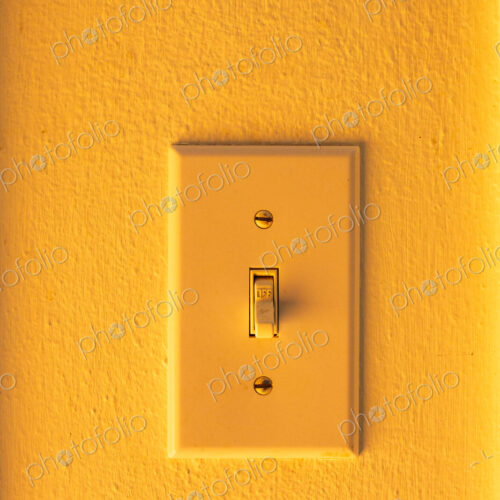 An orange wall and an orange rocker electric light switch, An orange wall and an orange rocker electric light switch,