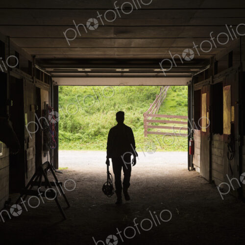 An organic farm in the Catskills. A man walking through a stable.