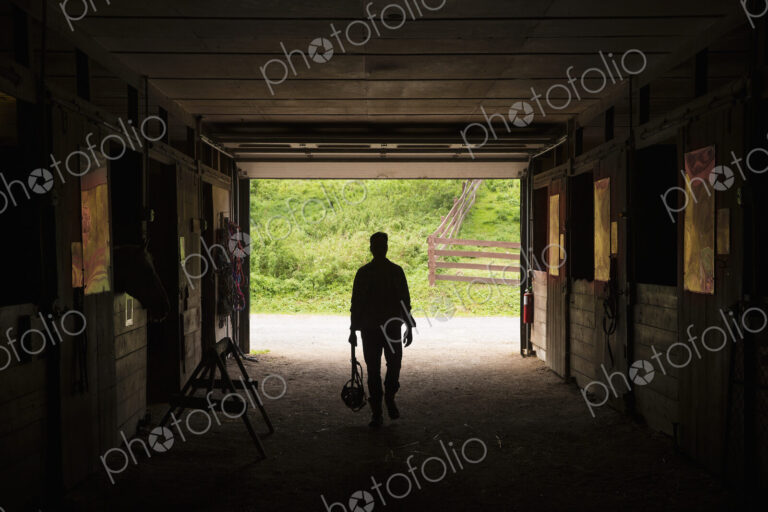 An organic farm in the Catskills. A man walking through a stable.