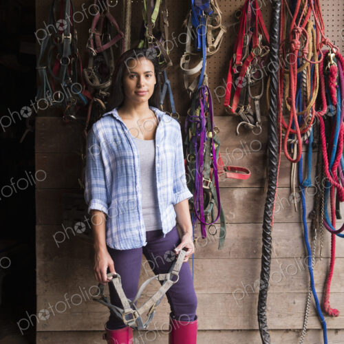 An organic farm in the Catskills. A person standing in a tack room in a stable.