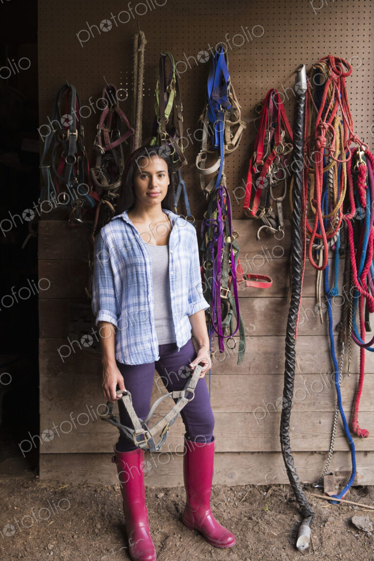 An organic farm in the Catskills. A person standing in a tack room in a stable.