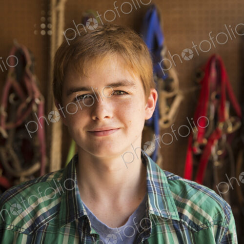 An organic farm in the Catskills. A person standing in a tack room in a stable.