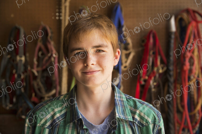 An organic farm in the Catskills. A person standing in a tack room in a stable.