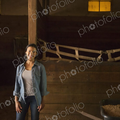 An organic farm in the Catskills. A woman in a horse stable.