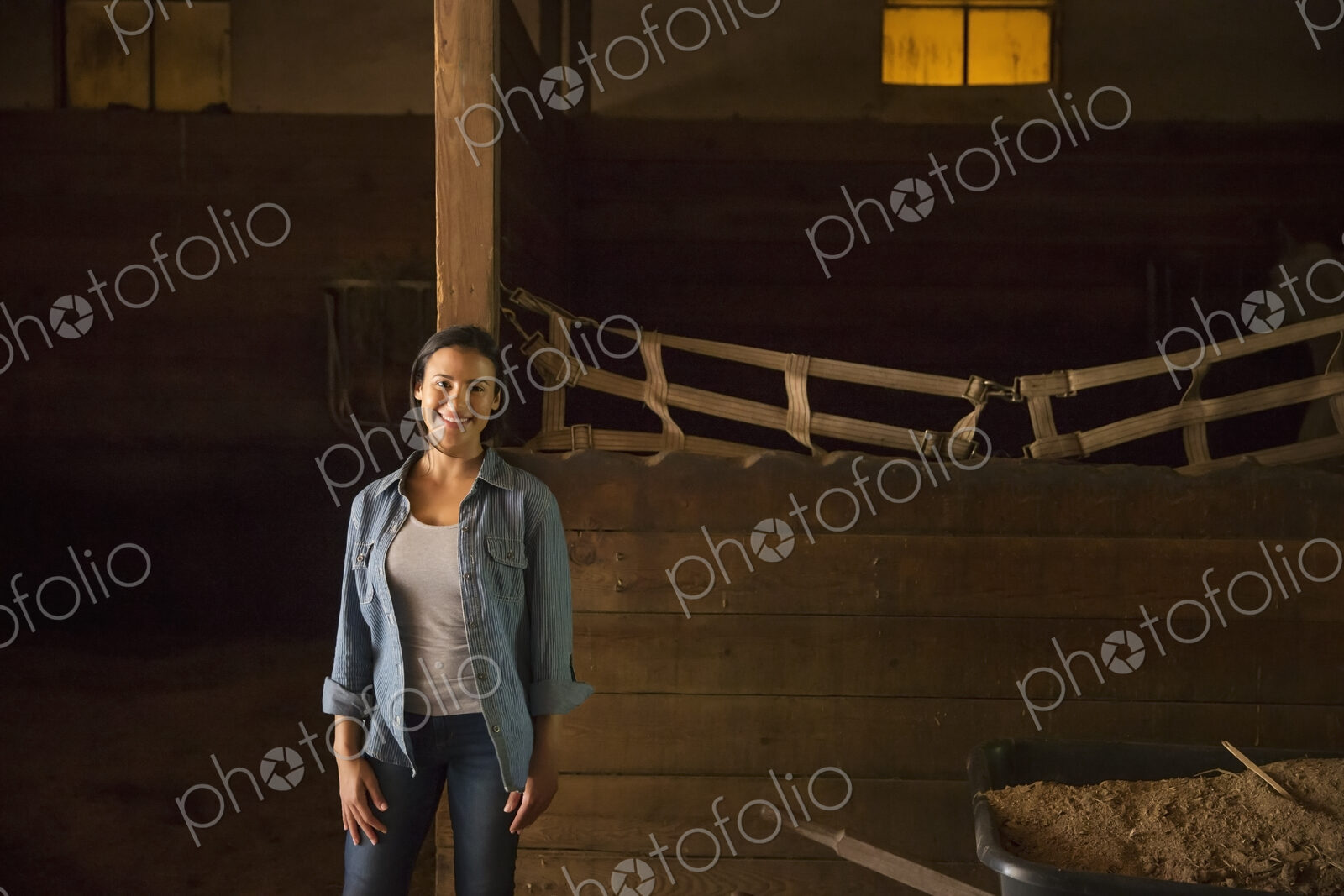 An organic farm in the Catskills. A woman in a horse stable.