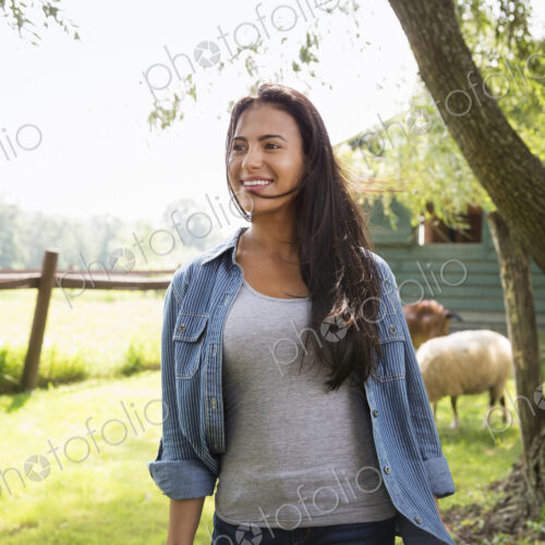 An organic farm in the Catskills. A woman in a paddock with a sheep.