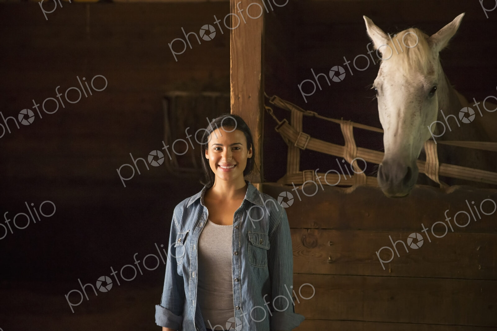 An organic farm in the Catskills. A woman standing in a stable, with a white horse…
