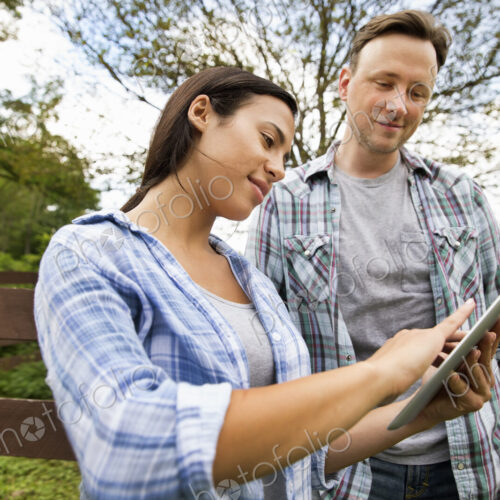 An organic farm in the Catskills. Two people looking at the screen of a digital tablet.