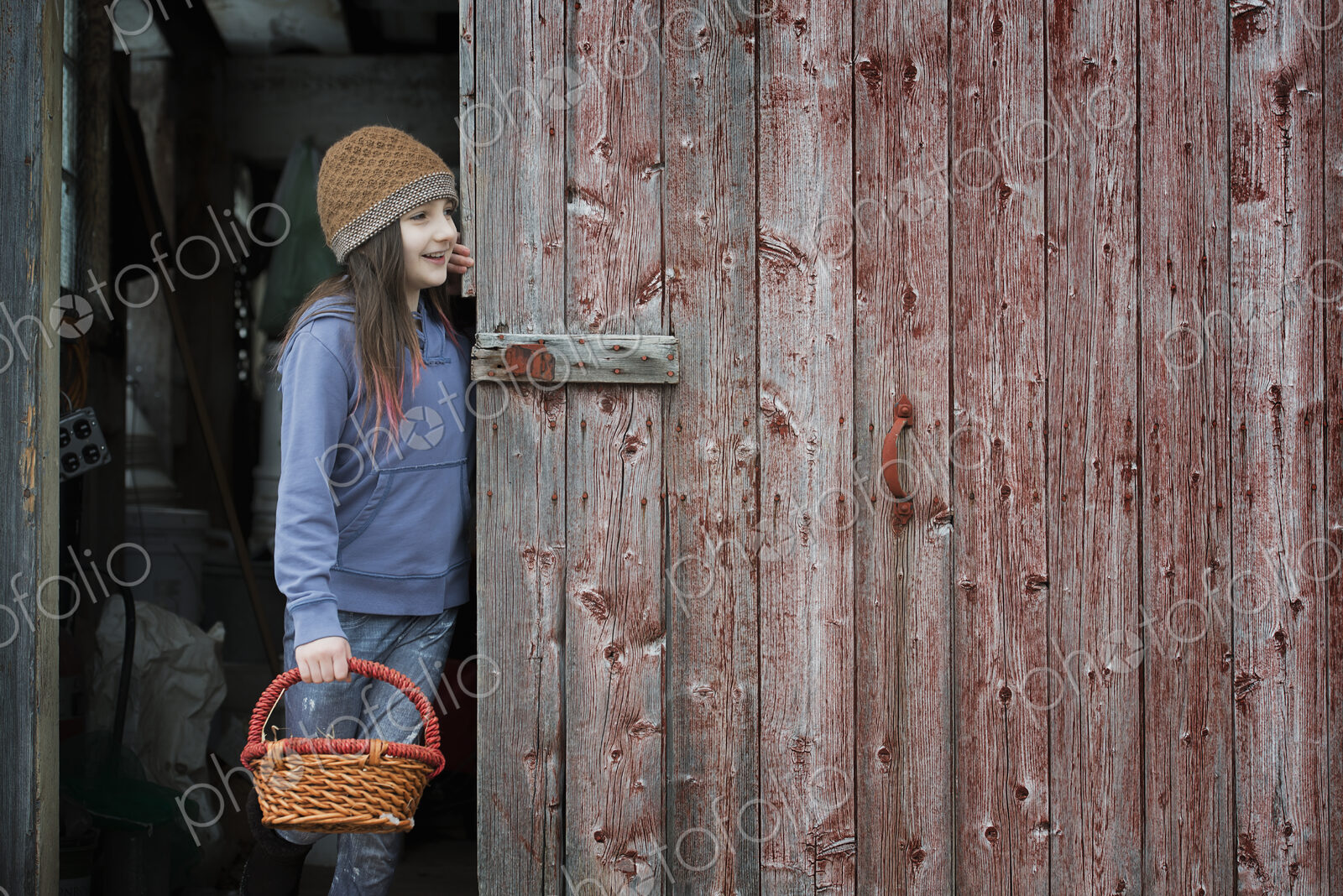 An organic farm in upstate New York, in winter. A girl in a barn doorway with a basket.
